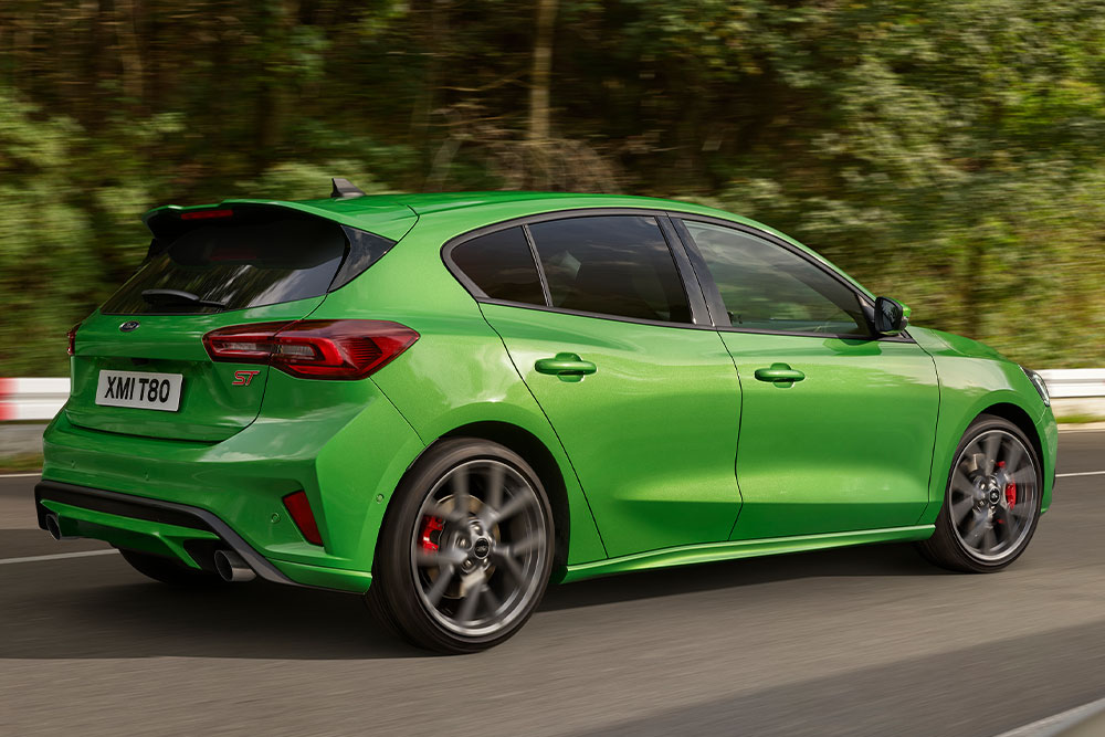 Vue arrière d’une Ford Focus ST à hayon de couleur Mean Green roulant sur un circuit.