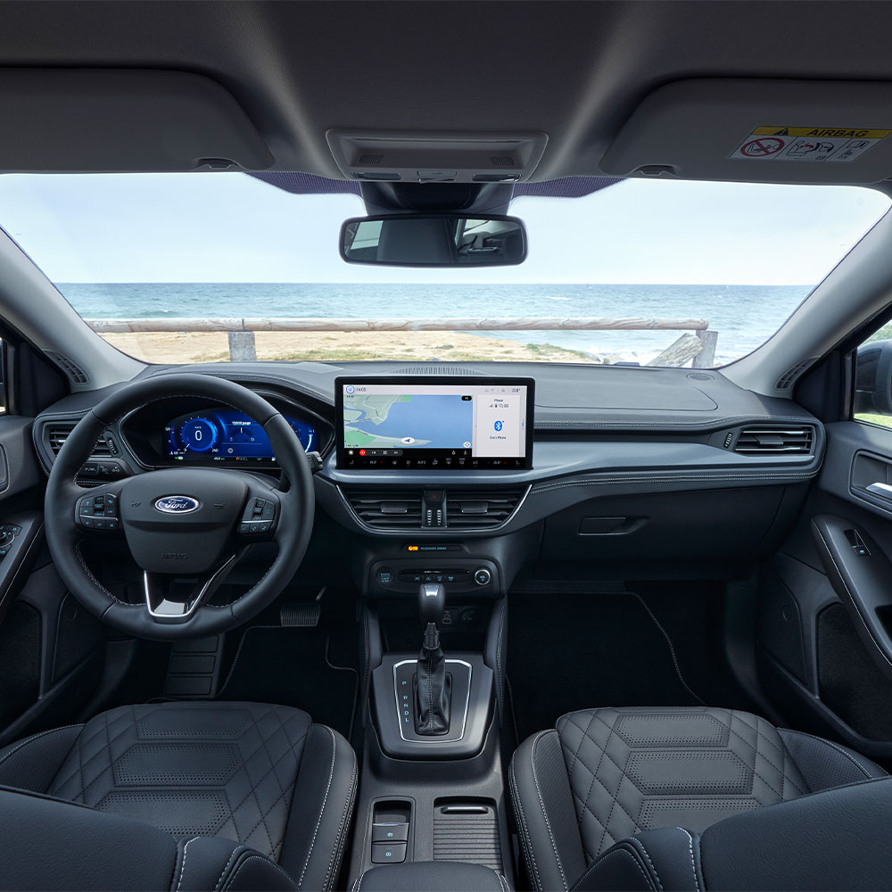 Vue intérieure de la Ford Focus montrant la planche de bord, le volant et l’écran d’infodivertissement.