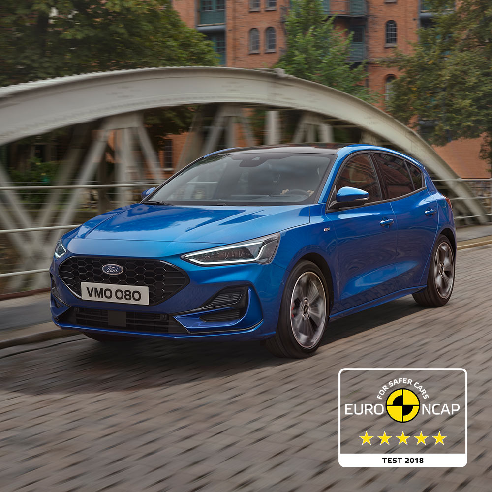 Une Ford Focus de couleur bleue est garée sur un pont; dans l’angle inférieur droit se trouve le badge de sécurité cinq étoiles Euro NCAP.