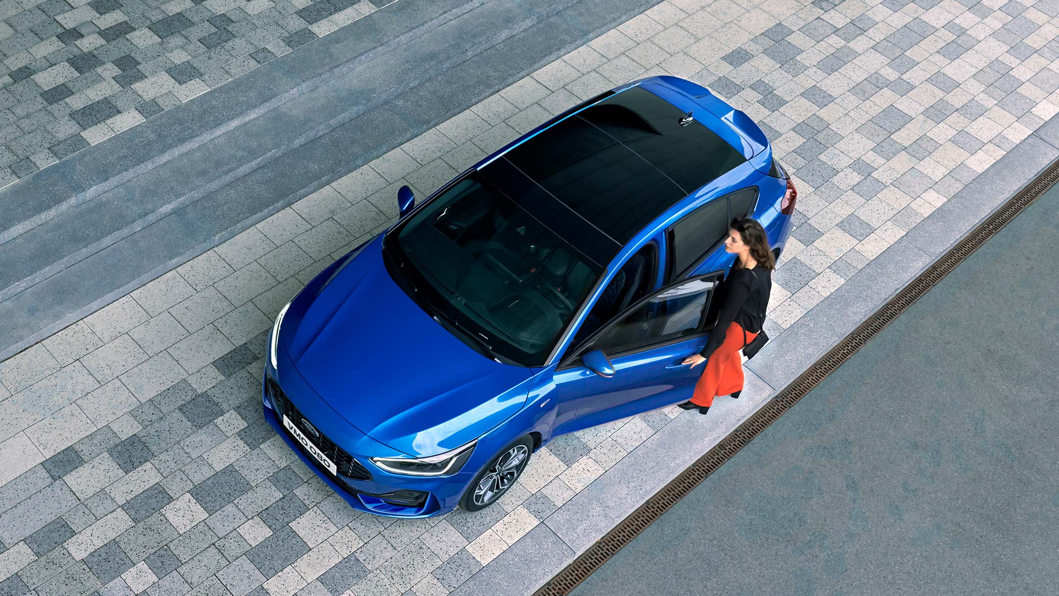 Ford Focus couleur bleue. Vue de face aux trois quarts d’en haut, avec vue sur le toit ouvrant panoramique.