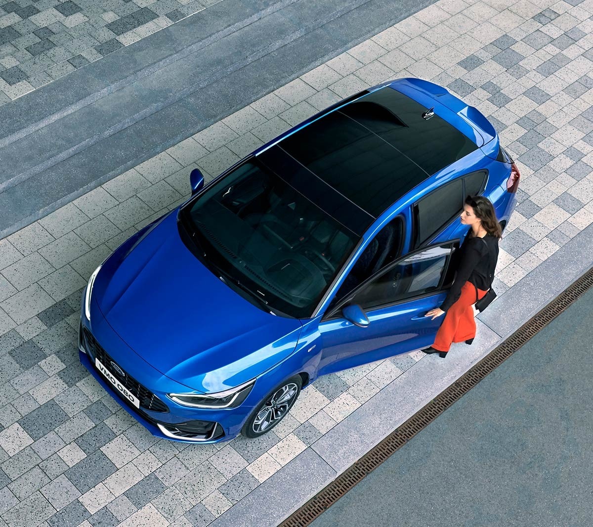 Ford Focus couleur bleue. Vue de face aux trois quarts d’en haut, avec vue sur le toit ouvrant panoramique.