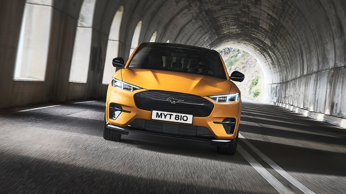 Ford Mustang Mach-E GT couleur orange. Vue de face, roulant dans un tunnel.