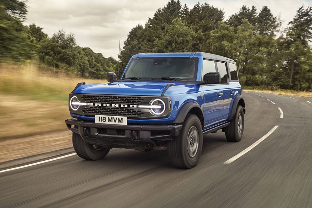 Vue de face du nouveau Ford Bronco bleu roulant à la campagne.