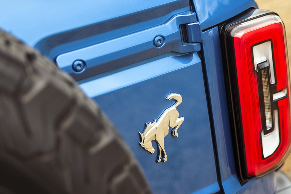 Gros plan des détails de la marque à l'arrière d'un Ford Bronco bleu.