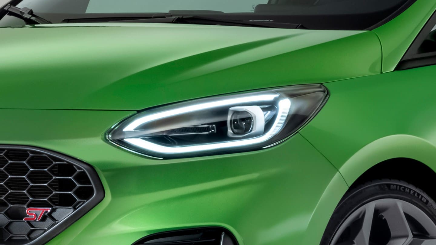 Ford Fiesta ST couleur verte. Vue détaillée d’un phare avant.