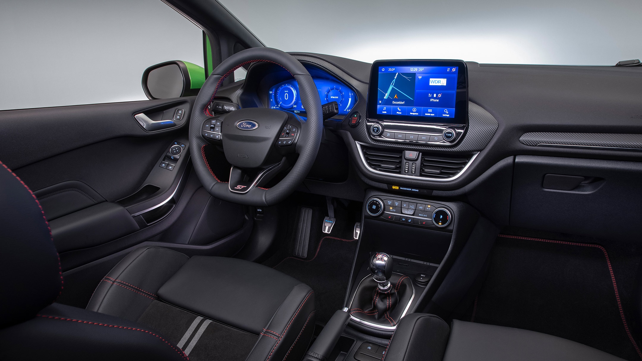 Ford Fiesta ST. Vue intérieure du poste de conduite, avec volant, pommeau du levier de vitesses et tableau de bord numérique.