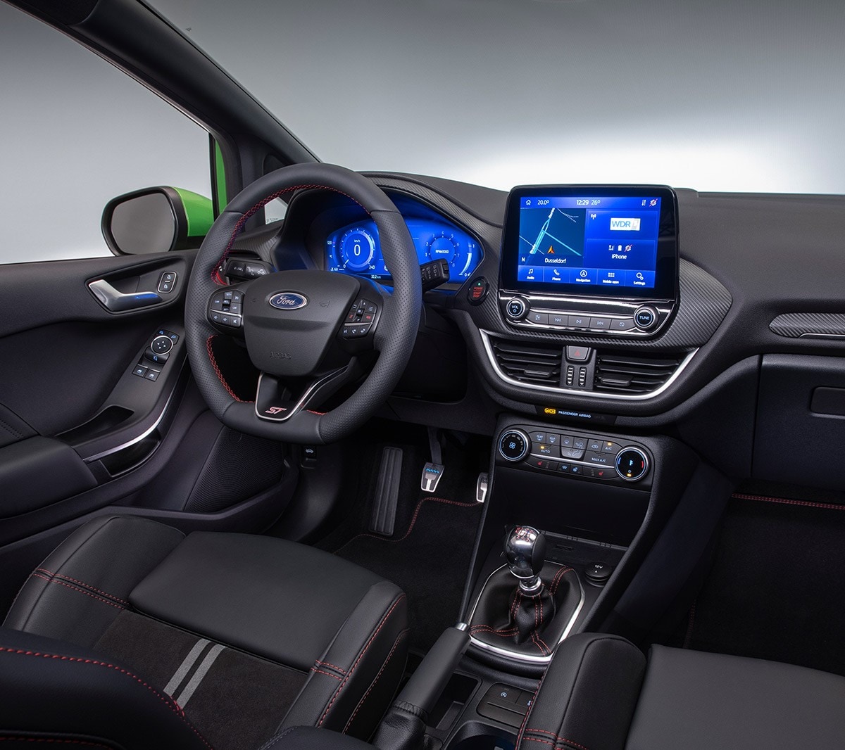 Ford Fiesta ST. Vue intérieure du poste de conduite, avec volant, pommeau du levier de vitesses et tableau de bord numérique.