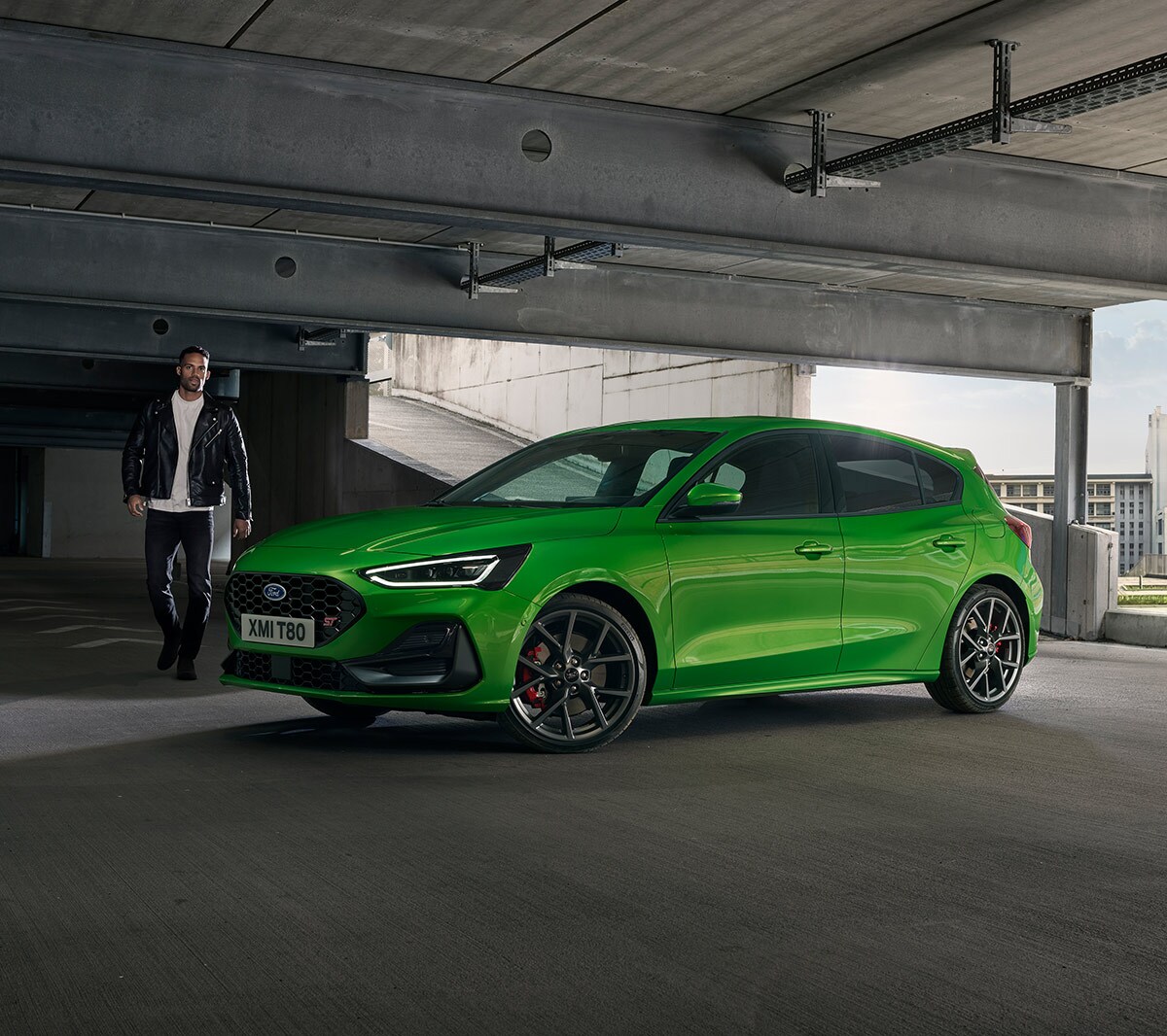 Ford Focus ST couleur verte. Vue de face aux trois quarts, roulant sur une route de campagne.