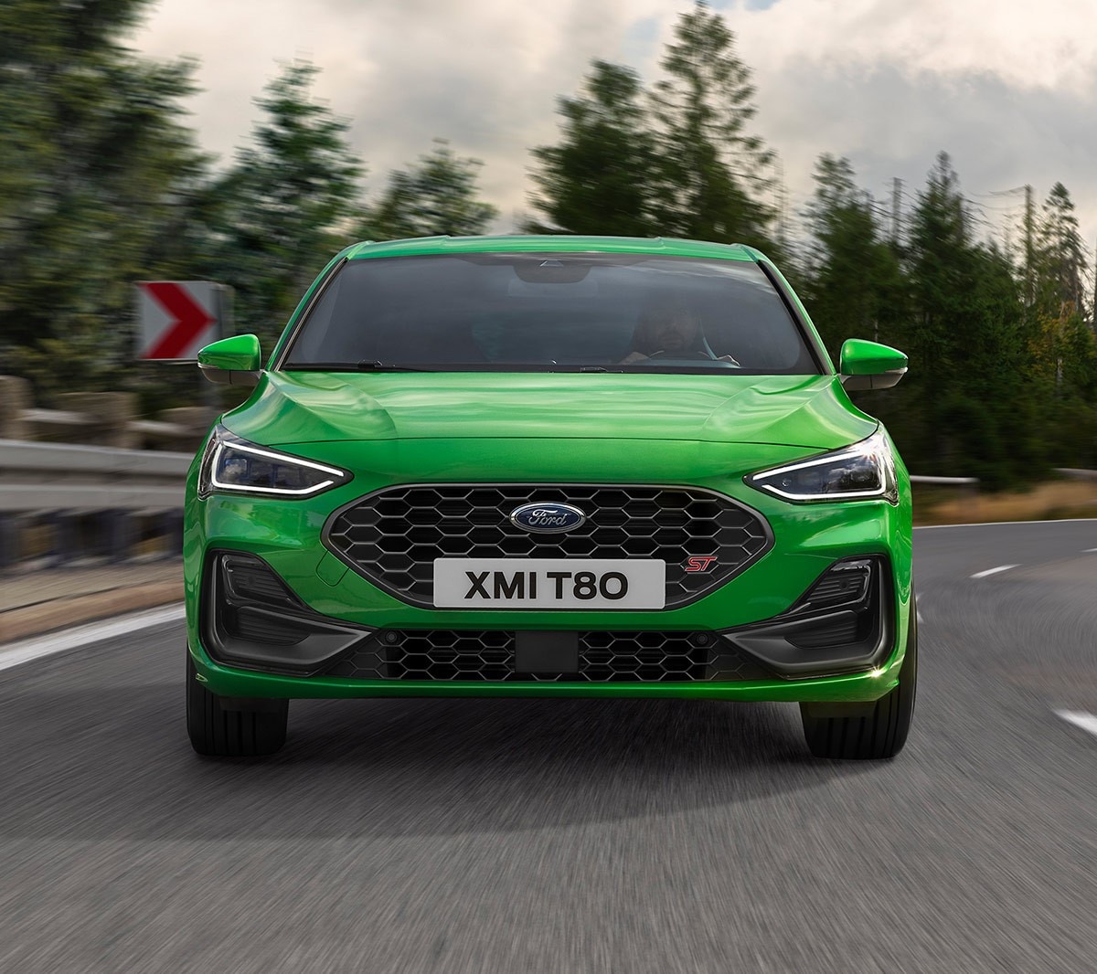 Ford Focus ST couleur verte. Vue de face, roulant sur une route.