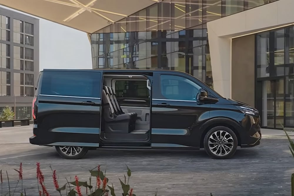 Ford E-Tourneo Custom noir avec porte coulissante ouverte, intérieur visible.