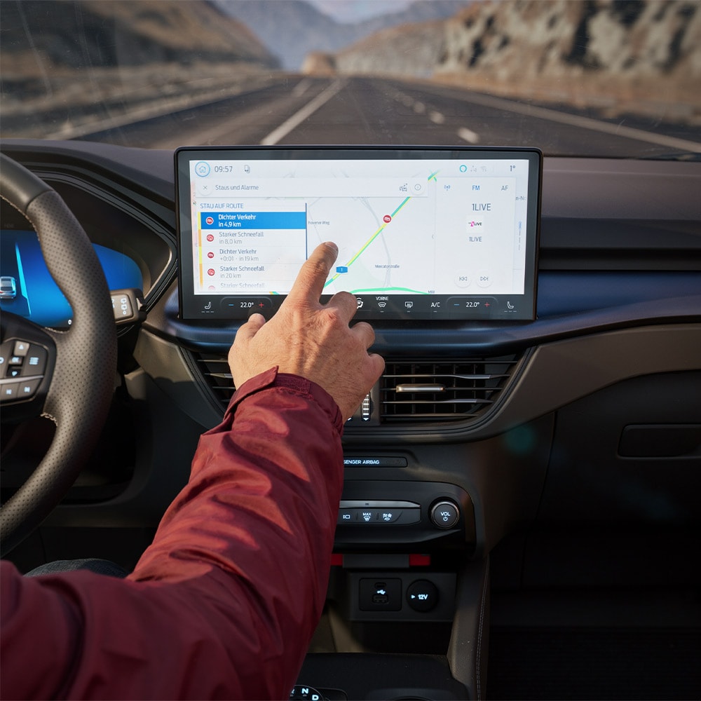 Un conducteur utilise le système de navigation connecté sur l’écran numérique d’un Ford Kuga BlueCruise Edition.