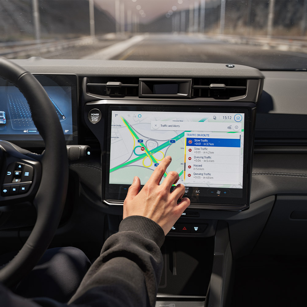 Un conducteur utilisant la Navigation Connectée sur l'écran numérique d'un Ford Puma Gen-E BlueCruise Edition.
