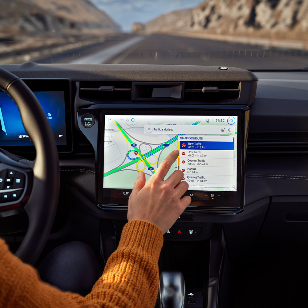 Un conducteur utilise le système de navigation connecté sur l’écran numérique d’un Ford Puma BlueCruise Edition.