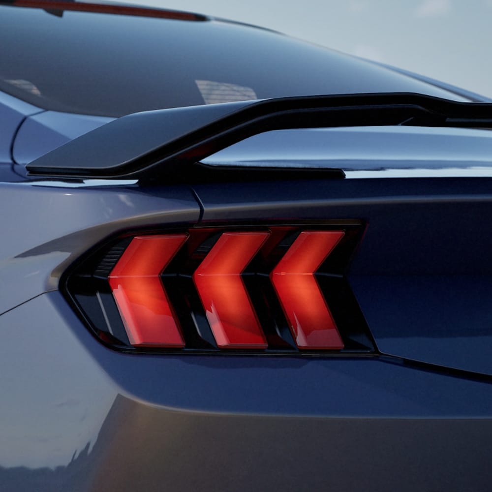 A close-up of the rear taillights of a Ford Mustang Dark Horse Fastback in Blue Ember paint.