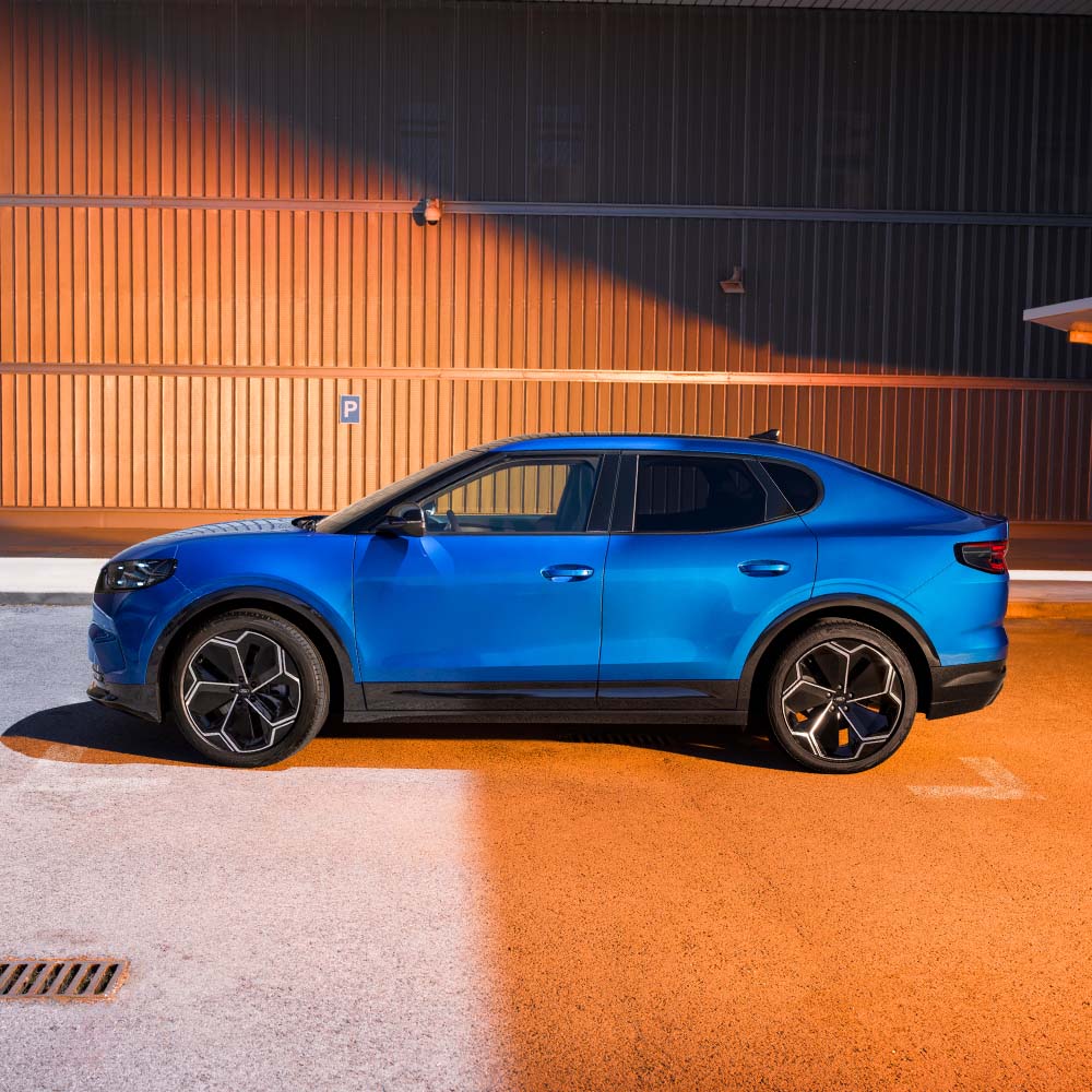 Vue latérale d’une Ford Capri bleue. La note de sécurité 5 étoiles de l’Euro NCAP pour 2024 affichée dans le coin supérieur droit.