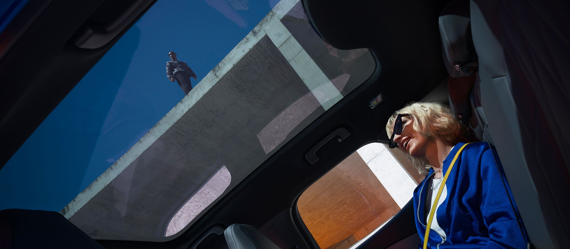 Une personne est assise dans une Ford Capri® neuve et profite du toit panoramique.