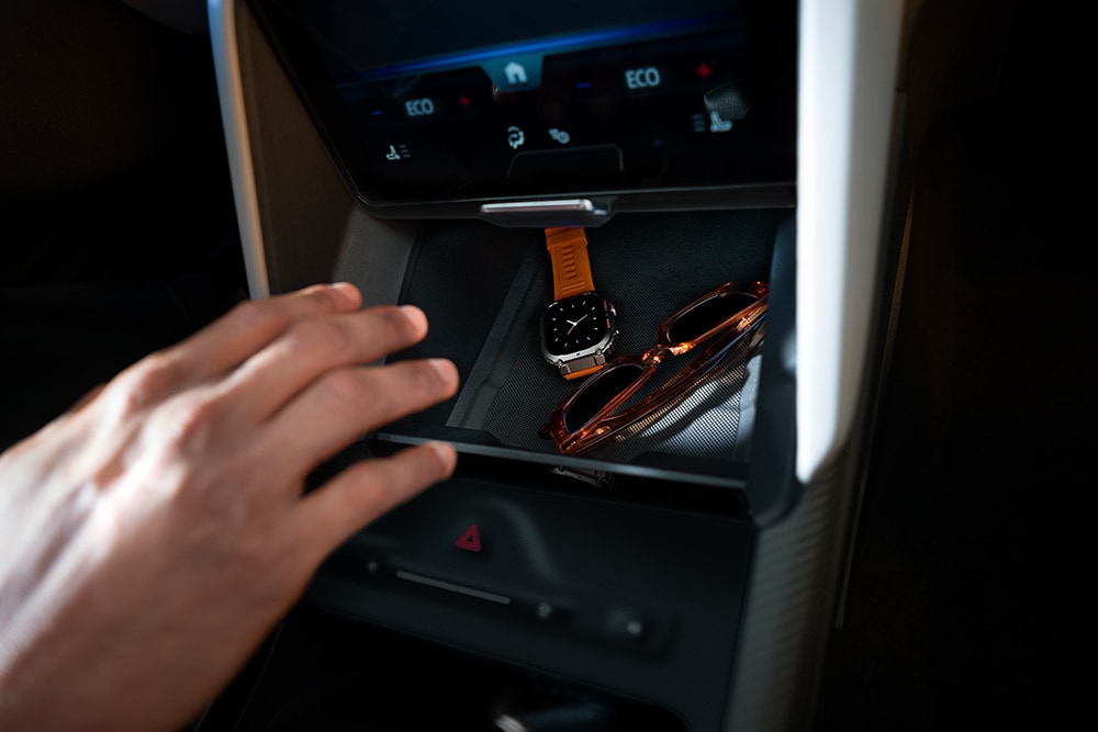 Une main dans le compartiment «My Private Locker» de la Ford Capri®. On y voit une montre et des lunettes de soleil.