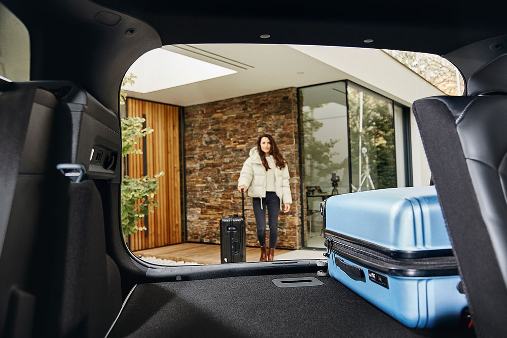 Le compartiment à bagages arrière du Ford Explorer, vu de l’intérieur du véhicule et contenant une valise bleue. 