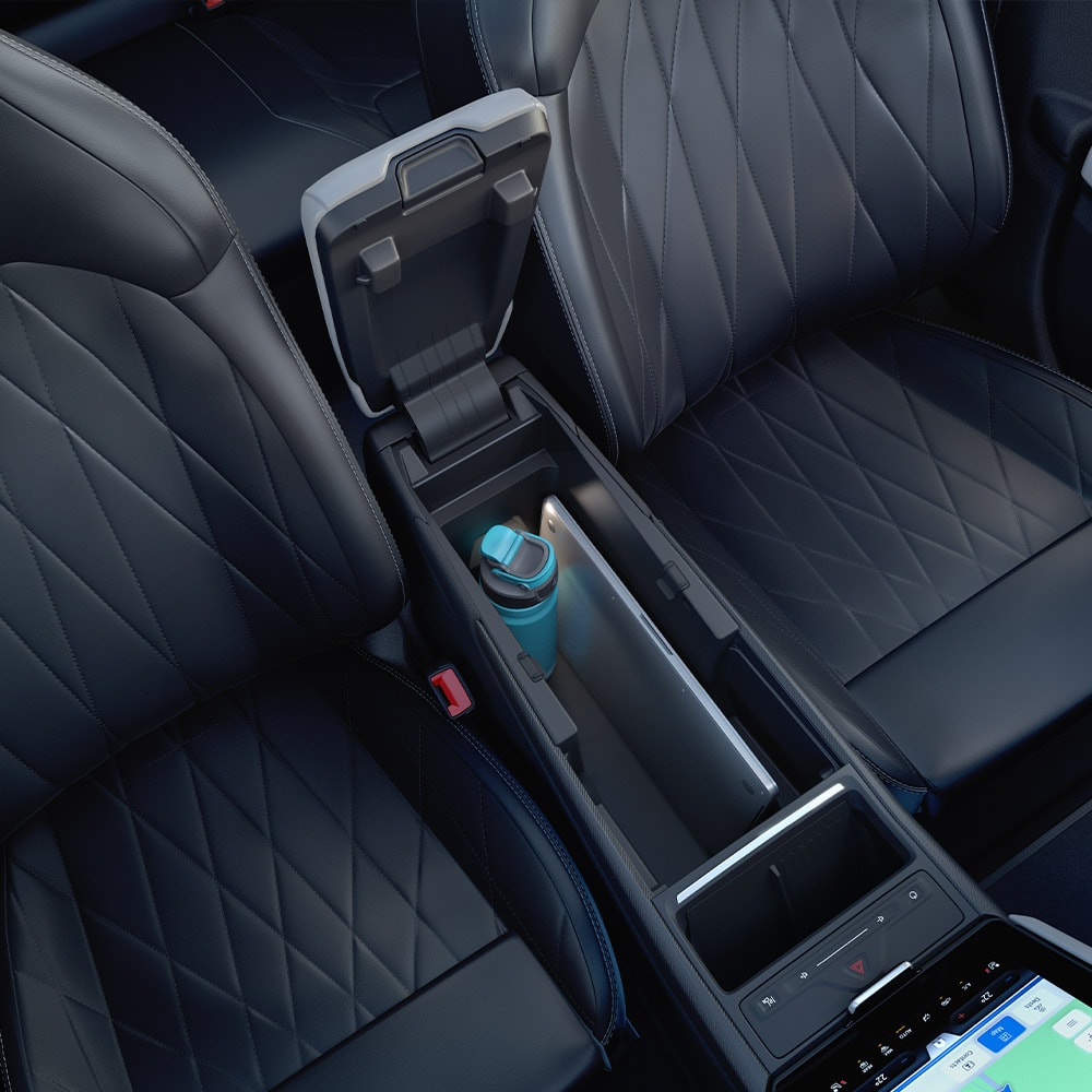 Gros plan sur un ordinateur portable et une bouteille d’eau placés dans la mégaconsole, située dans la console centrale du Ford Explorer. 