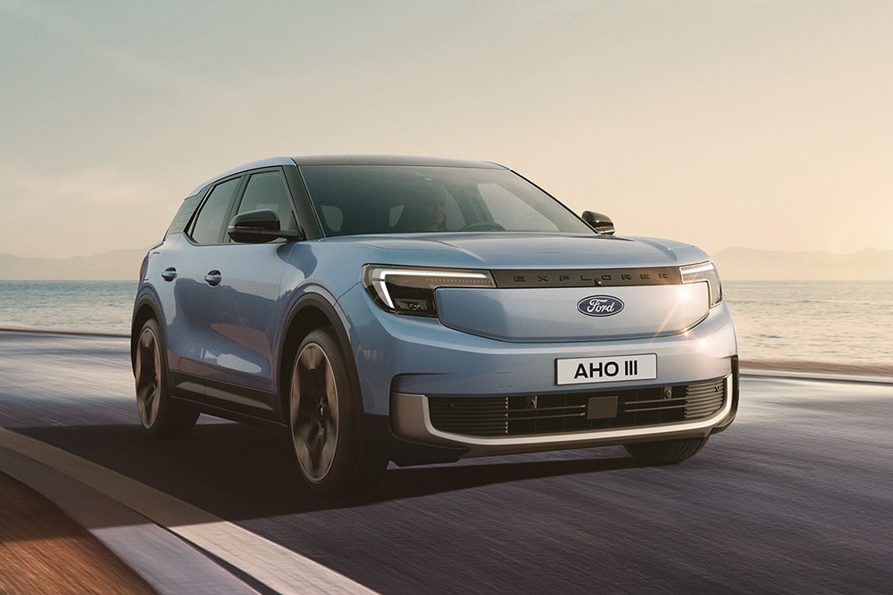 Le nouveau Ford Explorer® entièrement électrique en bleu circulant le long d’une route.
