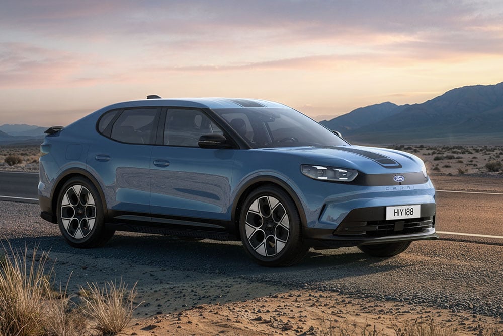 Ford Capri® Collection bleue  circulant sur une route de montagne poussiéreuse.