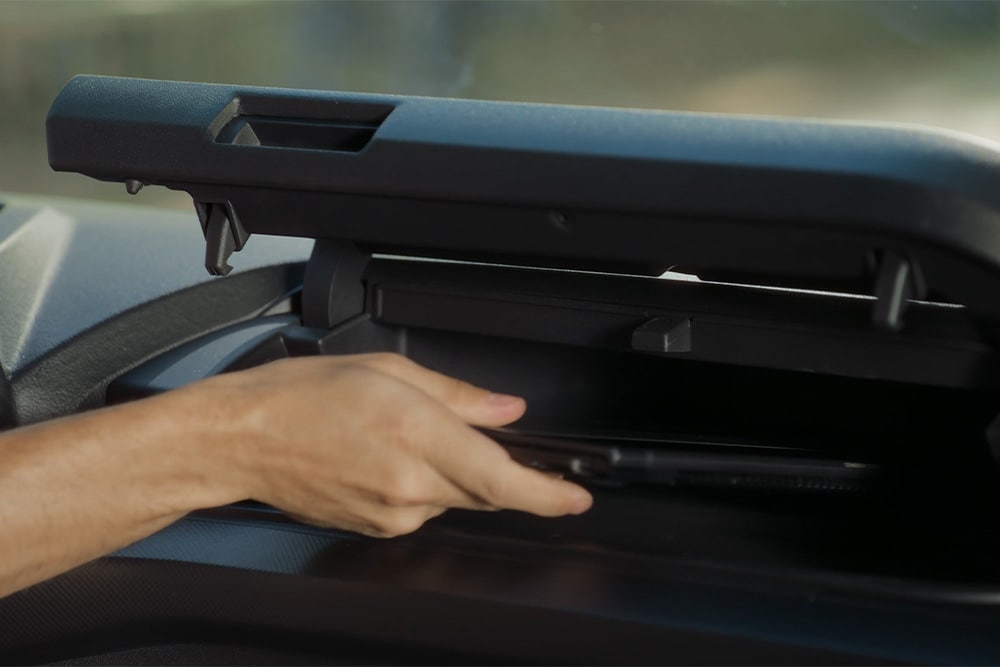 Personne rangeant des objets dans le compartiment de rangement du nouveau Tourneo Custom 