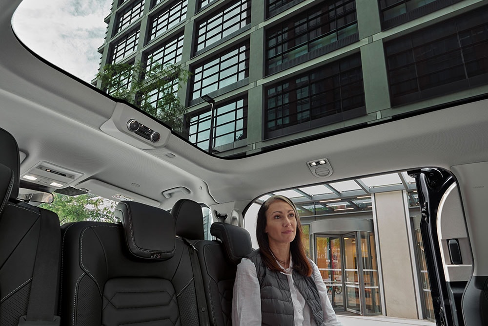 Personne regardant vers le toit panoramique du tout nouveau Tourneo Custom