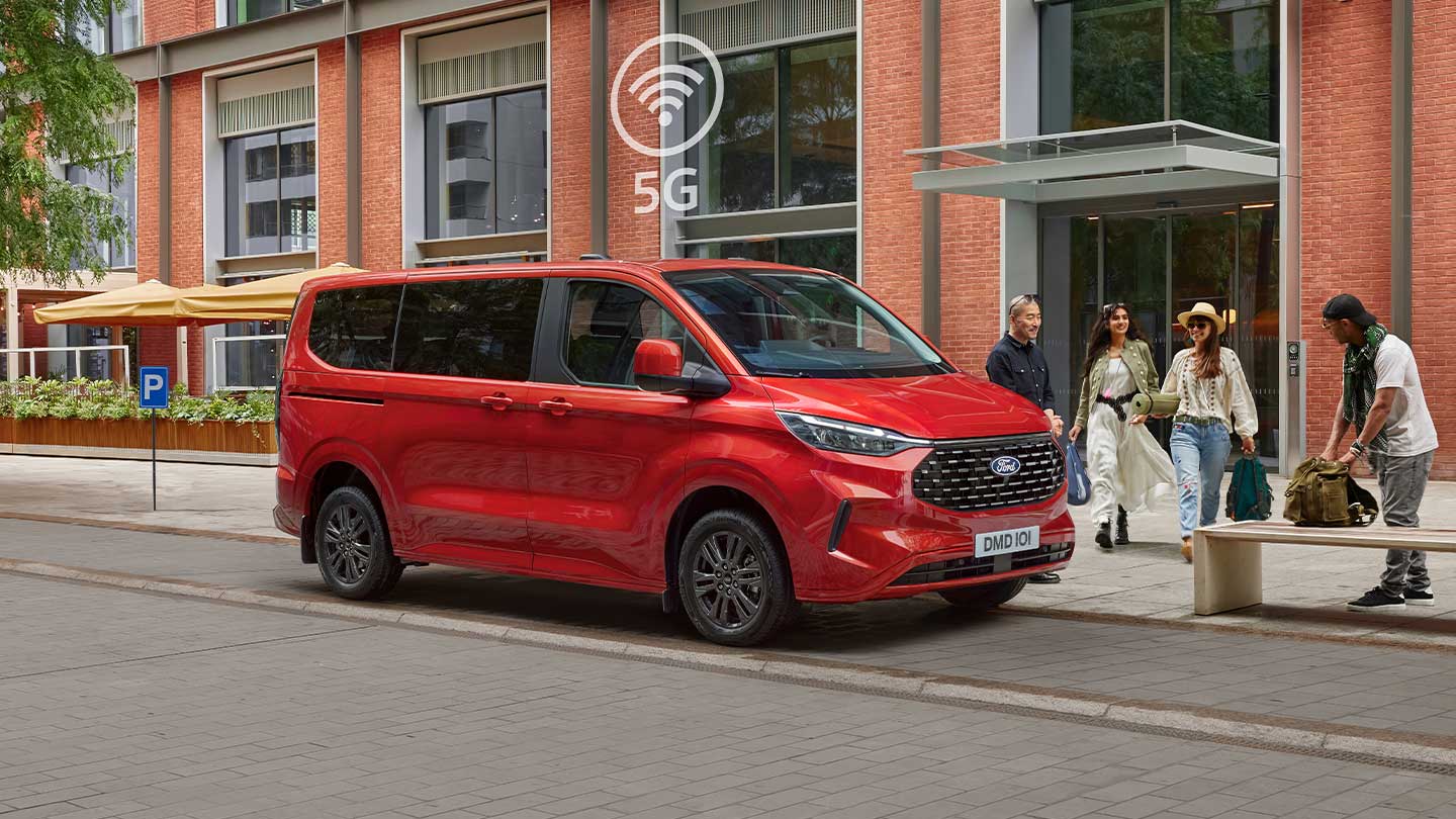 Tourneo Custom rouge tout neuf stationné avec des personnes autour
