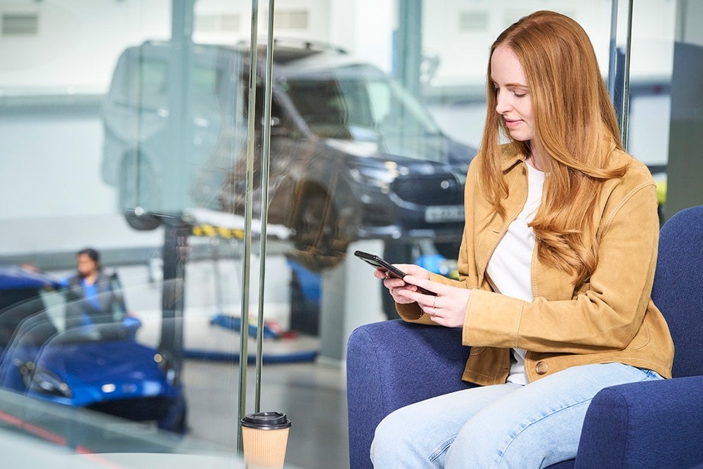 Un homme assis à une table avec un ordinateur portable et un téléphone mobile dans un bureau moderne