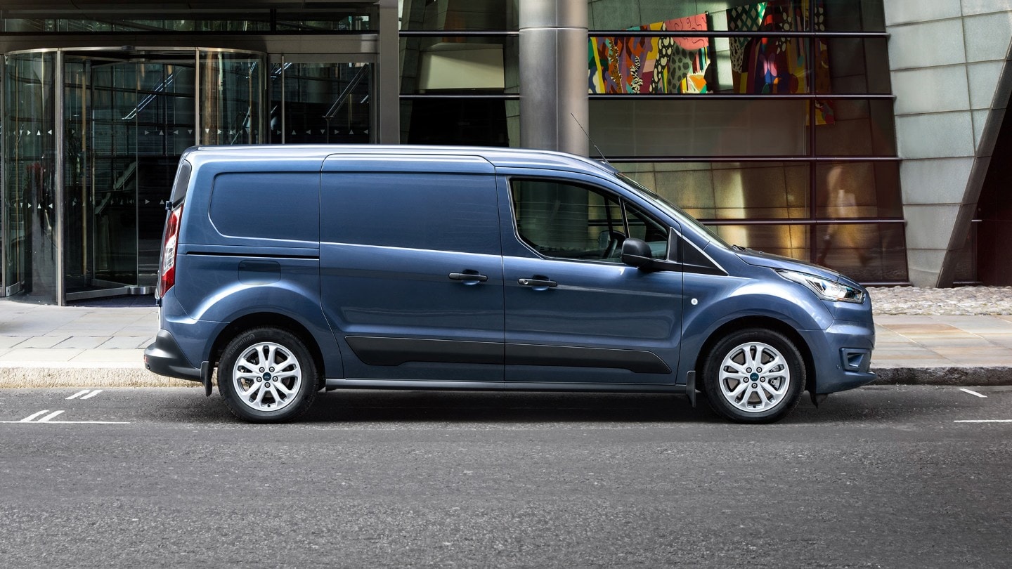 Ford Transit Connect bleue garée à côté d'un bâtiment moderne