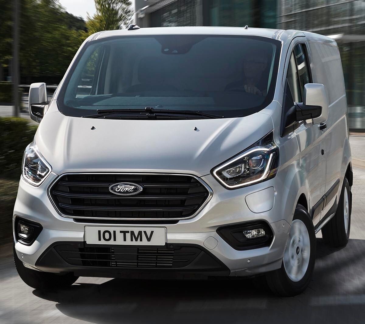 Ford Transit Custom camion-fourgon Plug-in Hybrid, couleur argent, vue de face aux trois quarts, roulant sur la route