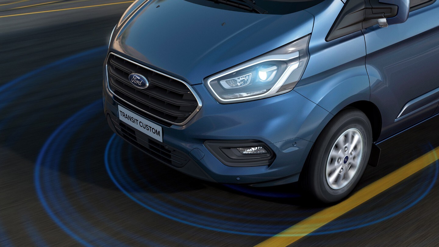 Ford Transit Custom couleur bleue, vue de face aux trois quarts, illustration de l’alerte de franchissement de ligne