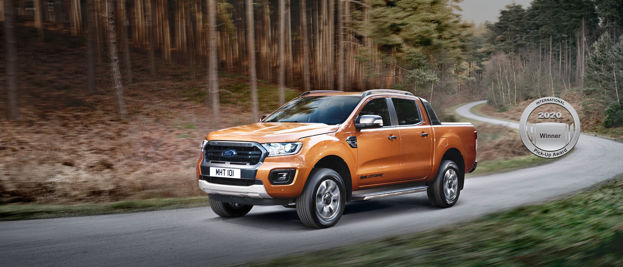 Orange Ford Ranger driving on a forest road