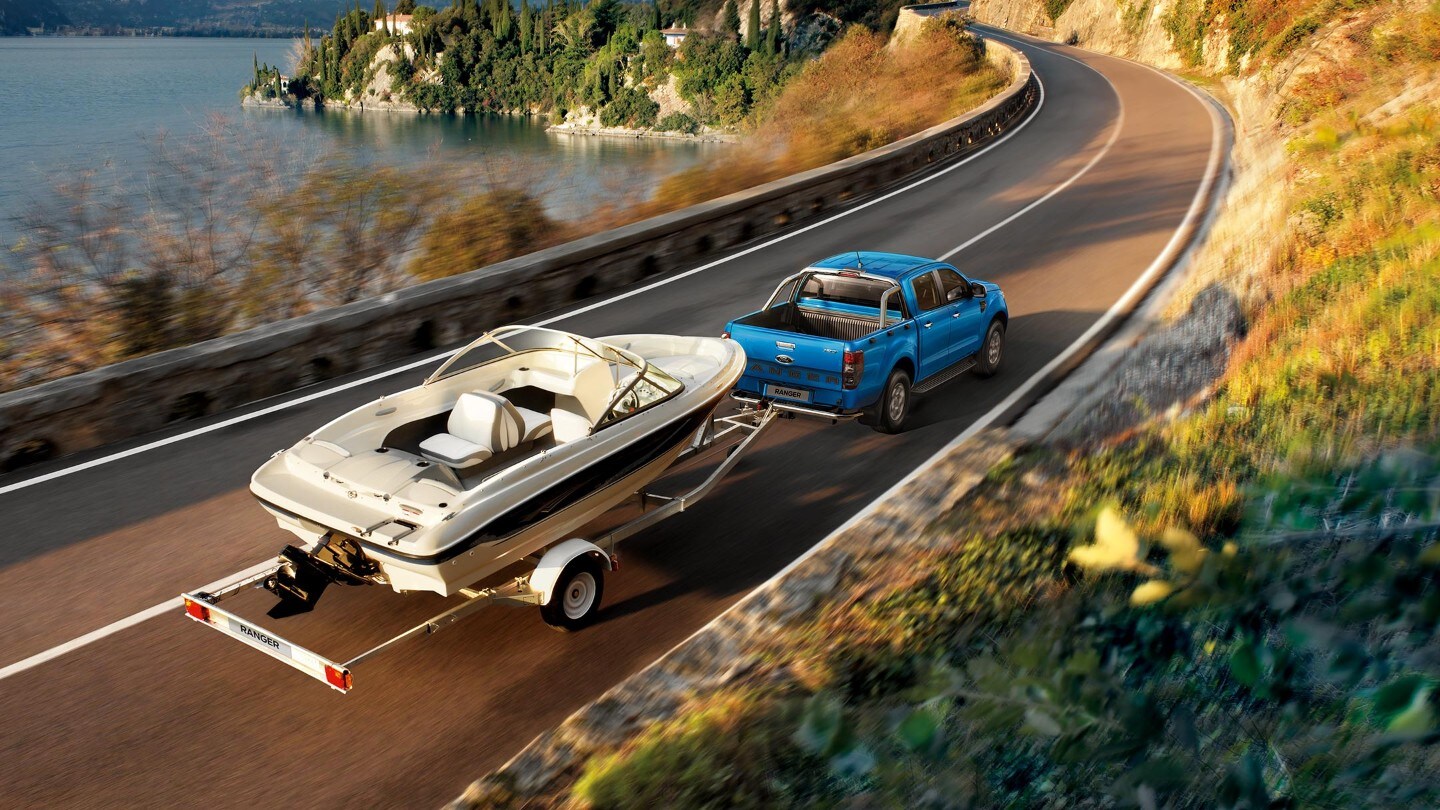 Ford Ranger couleur bleue, tracte une remorque transportant un bateau à moteur