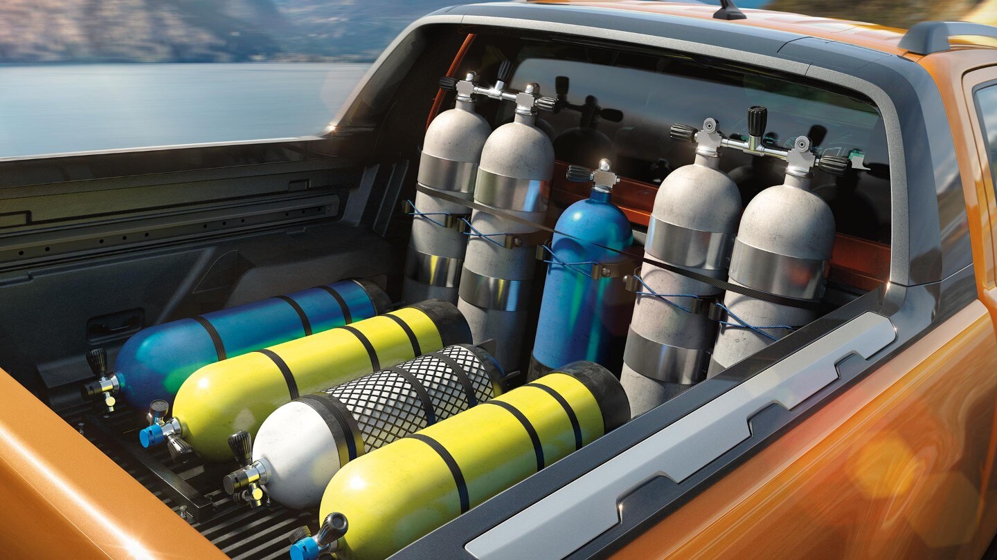 Ford Ranger couleur orange, détail de la surface de chargement chargée de bouteilles d’oxygène