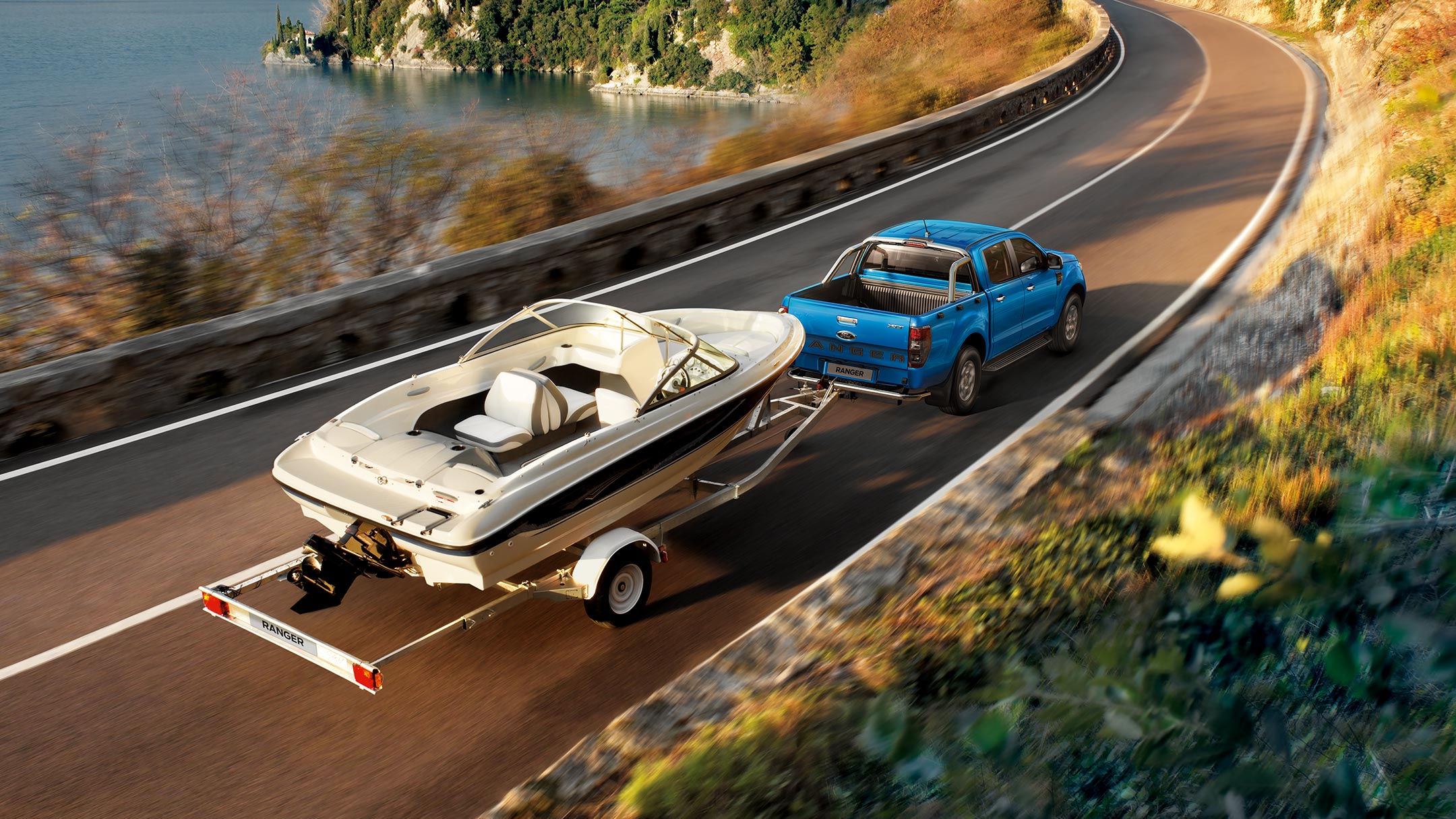 Ford Ranger bleu tire un bateau à moteur sur une remorque