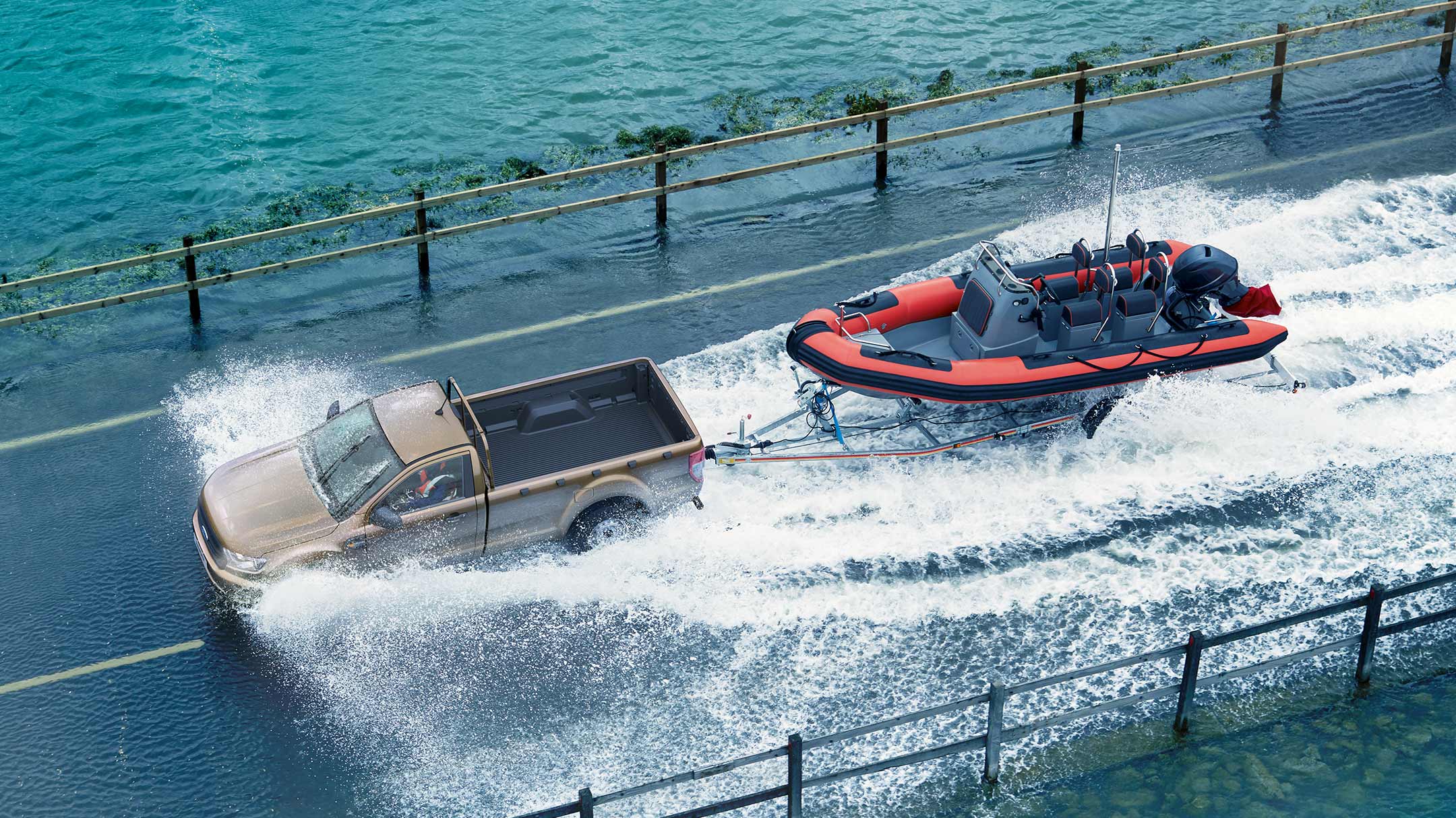 Un Ford Ranger, couleur champagne, tracte hors de l’eau une remorque avec un bateau.