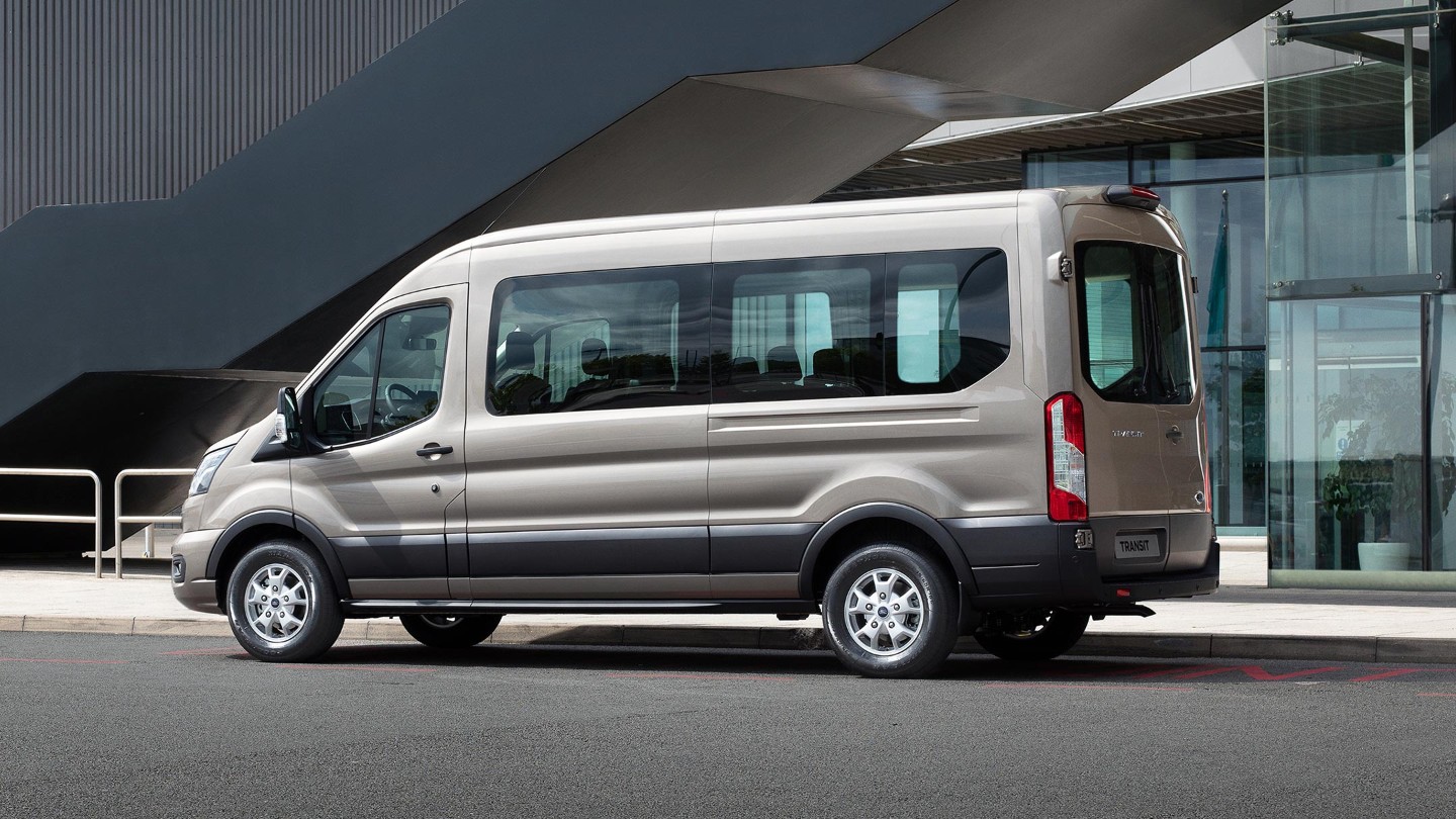 Ford Transit combi voiture argent Vue latérale se gare devant un bâtiment moderne 