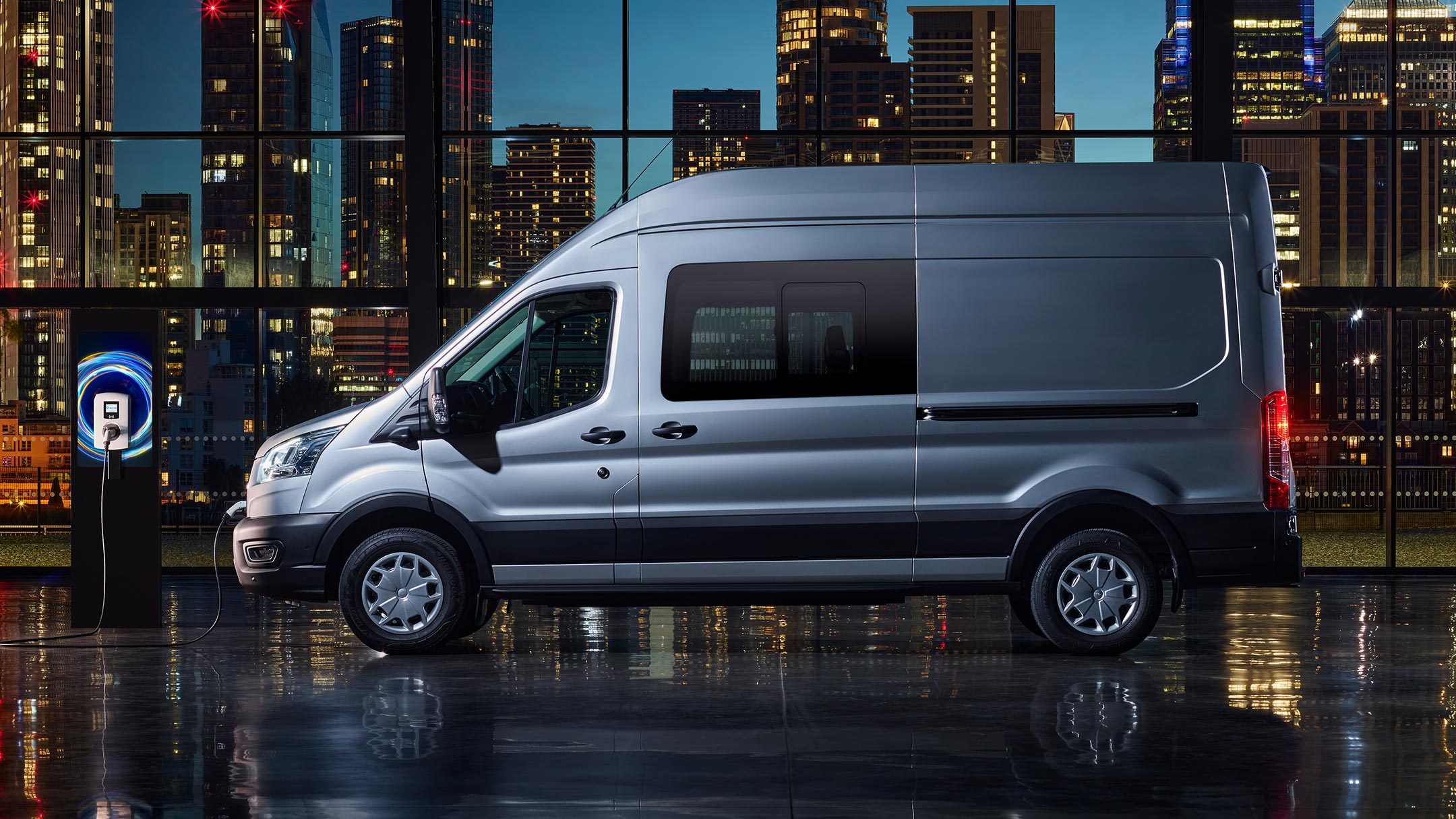 Ford E-Transit couleur argent, vue latérale pendant la charge