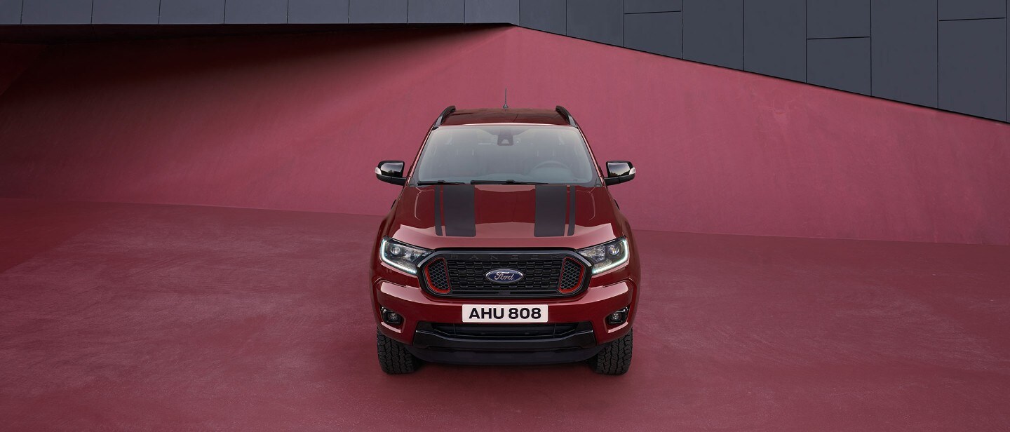 Ford Ranger Stormtrak rouge, vue de face, garé, avec fond rouge Ford Ranger Stormtrak rouge, vue de face, garé, avec fond rouge