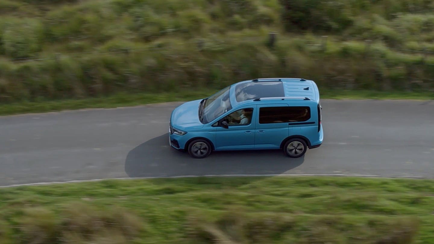 Ford Tourneo Connect couleur bleu clair, vue latérale aérienne, roulant sur une route de campagne