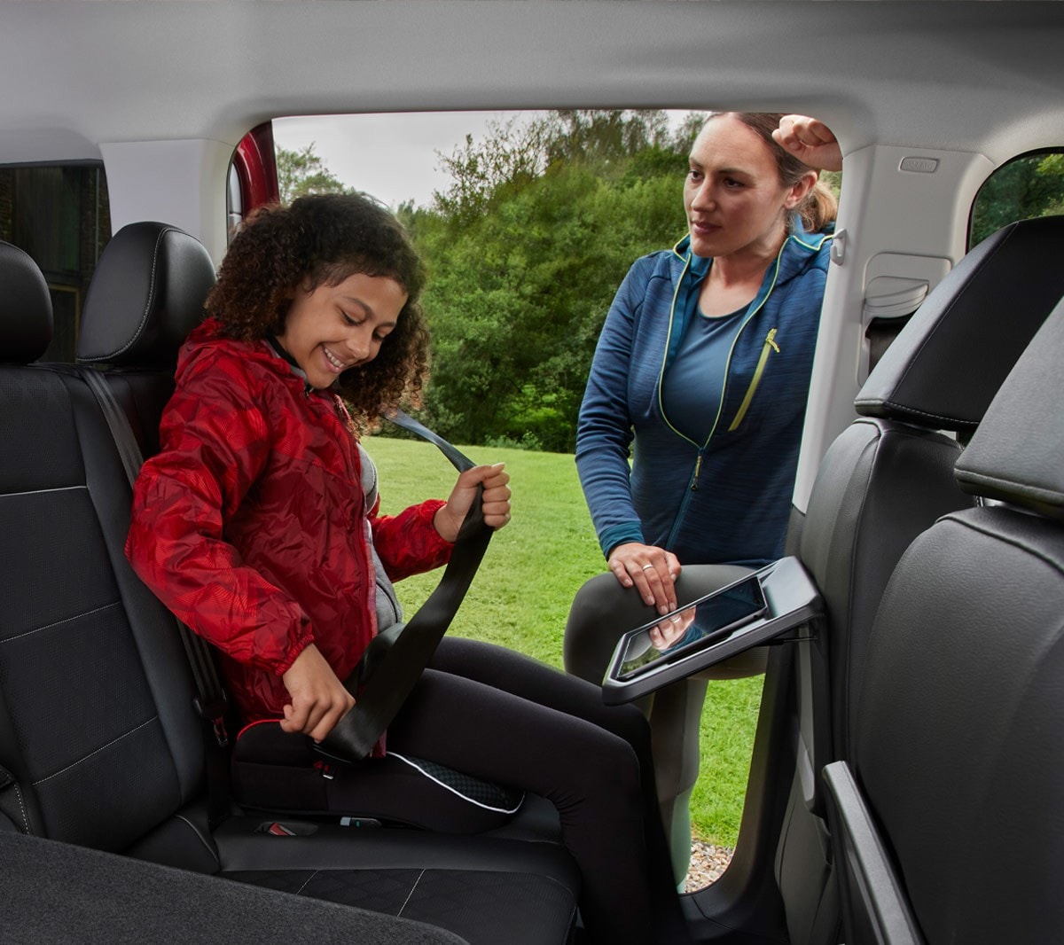 Ford Tourneo Connect, habitacle, deuxième et troisième rangées de sièges. Une fillette met sa ceinture