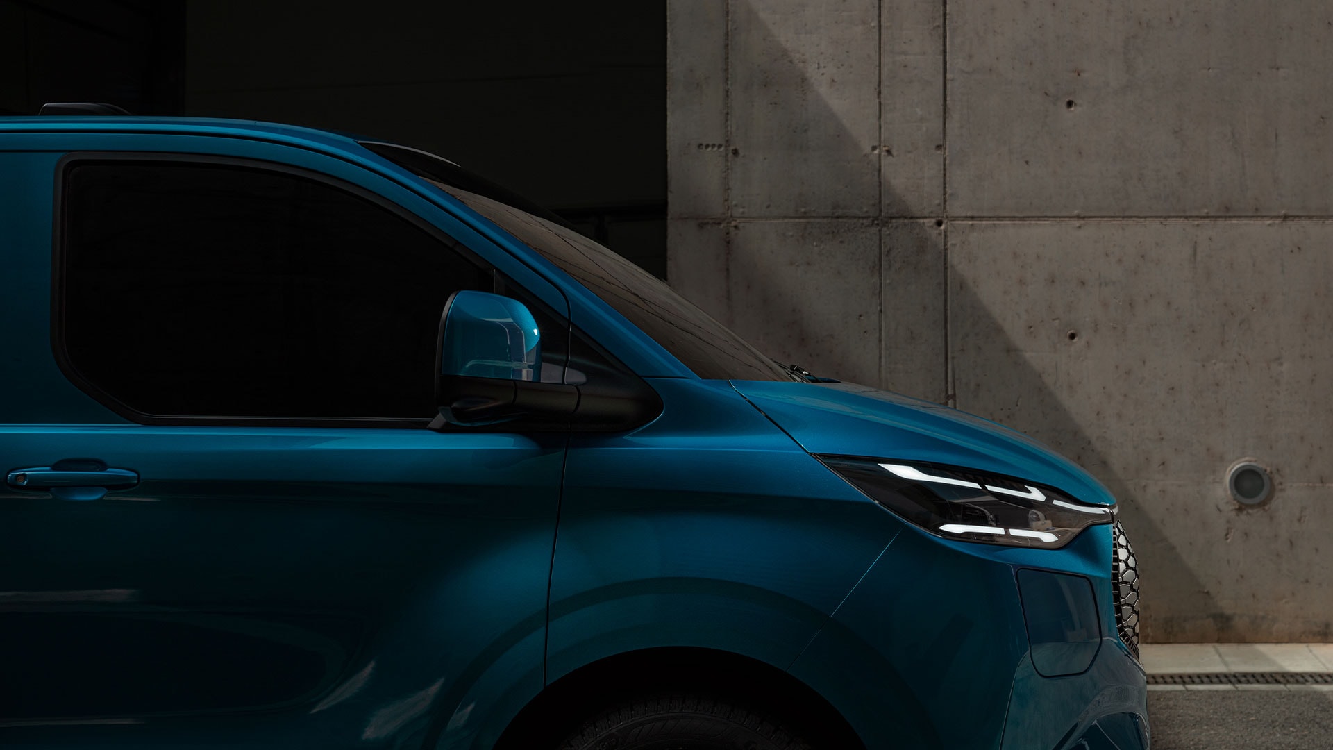 Gros plan sur le phare à LED d'un Ford E-Transit Custom bleu.