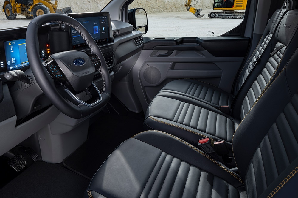 Vue intérieure d'un fourgon électrique Ford E-Transit Custom Sport avec sièges noirs et dorés. 