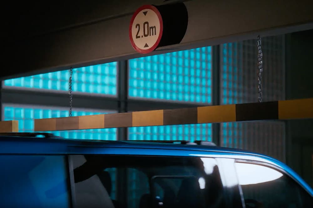 Ford E-Transit Custom bleu entrant dans un garage.
