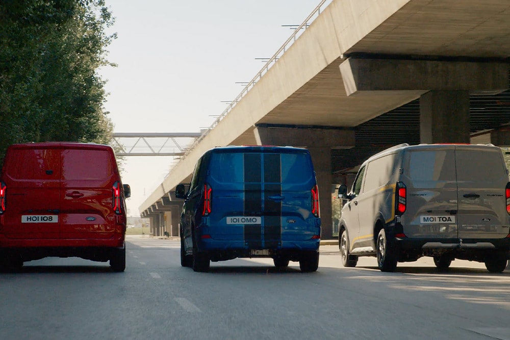 Trois fourgons Ford Transit Custom roulant sur l'autoroute.