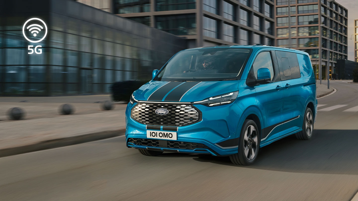 Une camionnette électrique Ford E-Transit Custom bleue circule en ville.