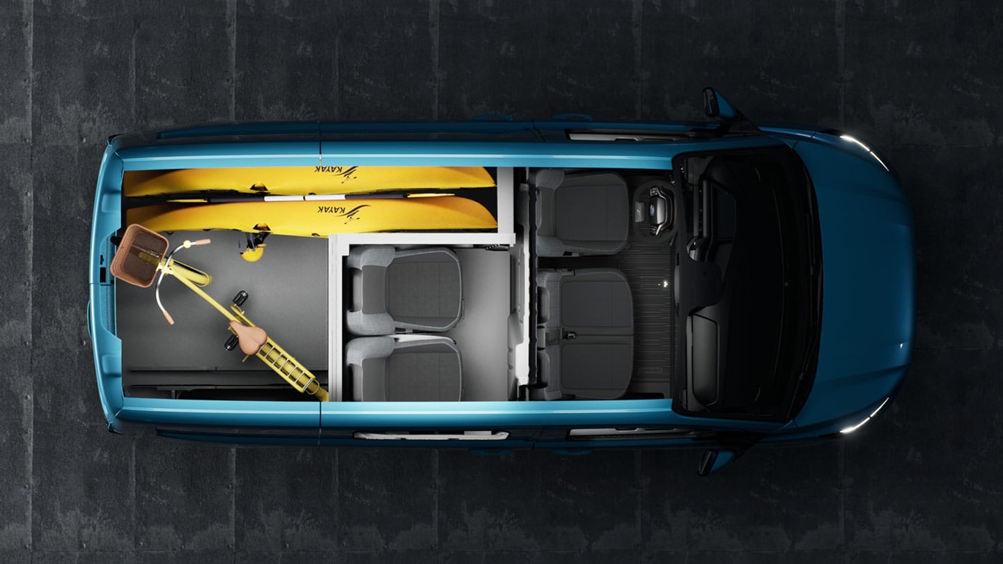 Intérieur d'une Ford Transit Custom avec un kayak et des vélos.