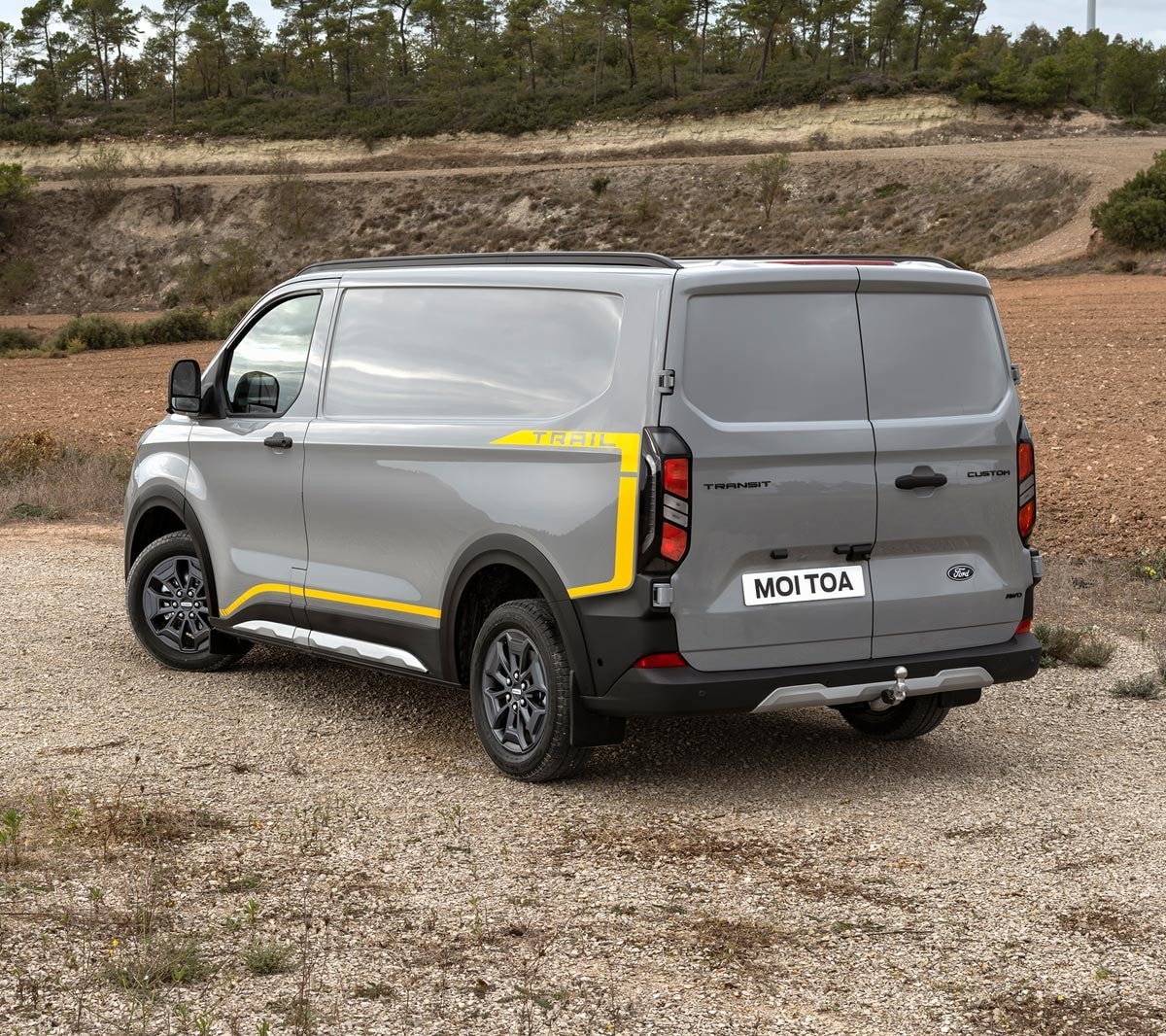 Ford Transit Trail parked on gravel road