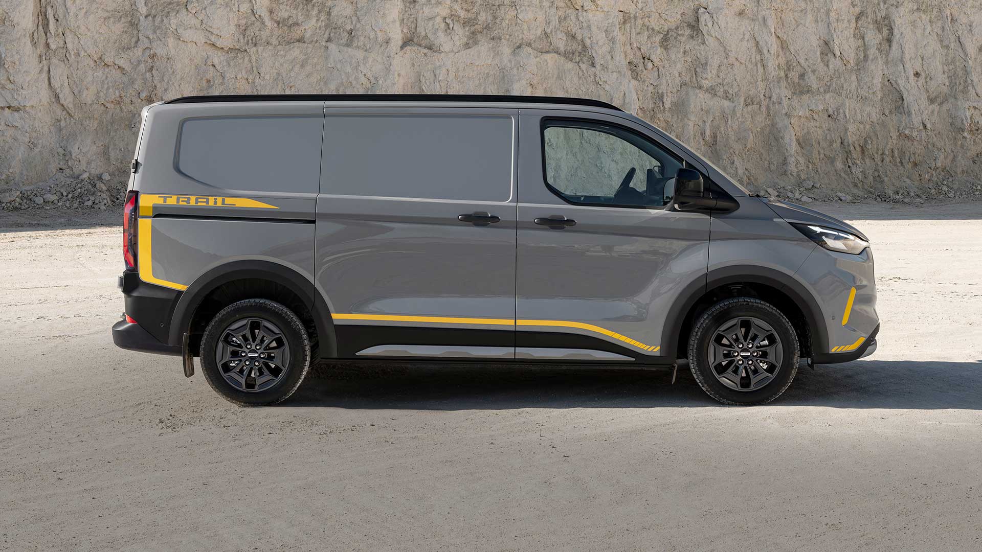 Camionnette Ford Transit Custom Trail grise avec des accents jaunes, vue latérale